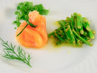 Lachsbeutelchen auf grünem Spargel   


